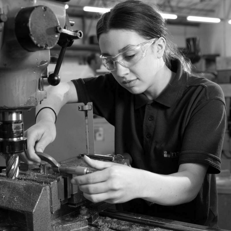 Engineering apprentice inspecting a machined part