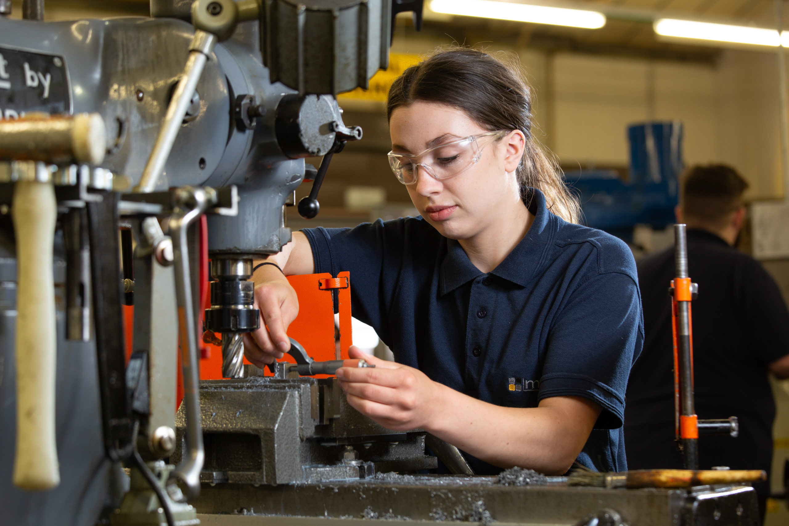 Technical Support Technician apprentice inspecting machined part