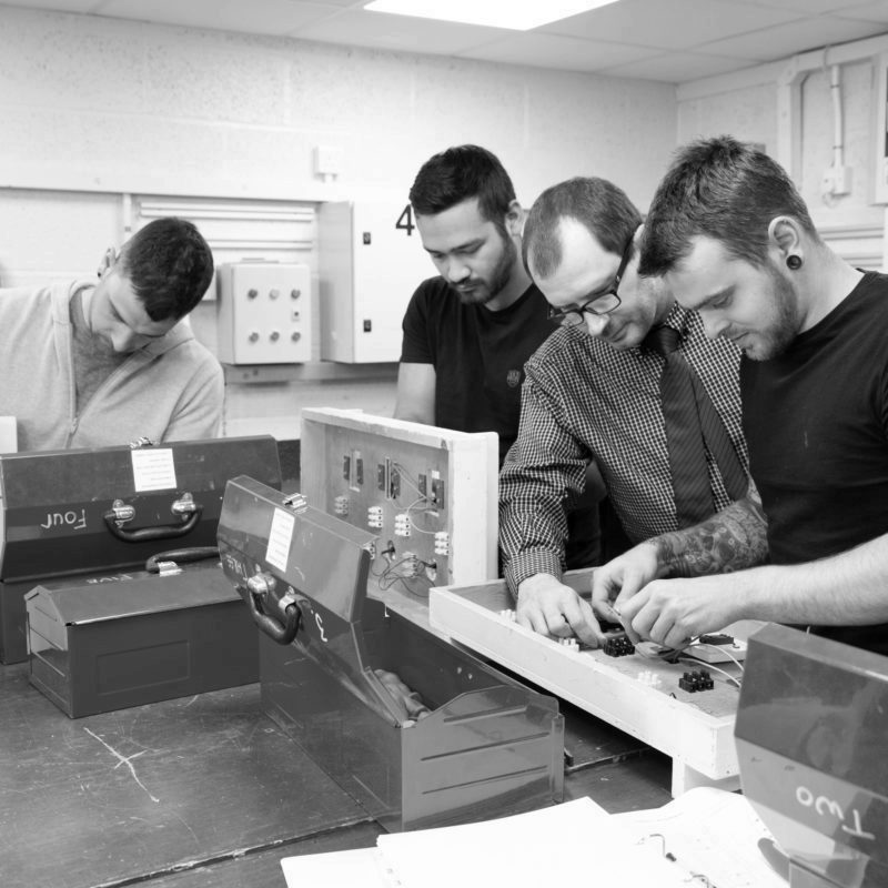 Engineers on training course creating electrical circuits