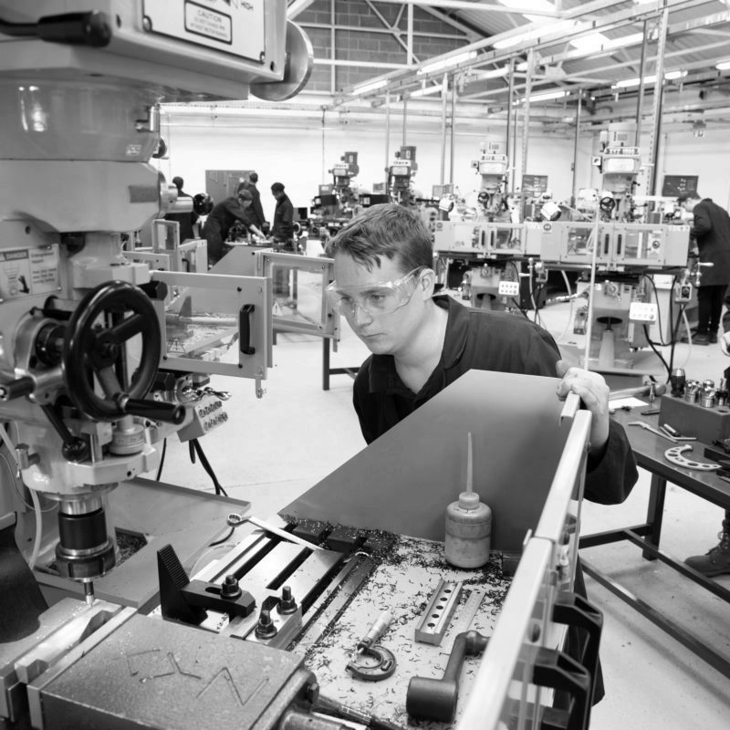 Engineering apprentice using milling machine