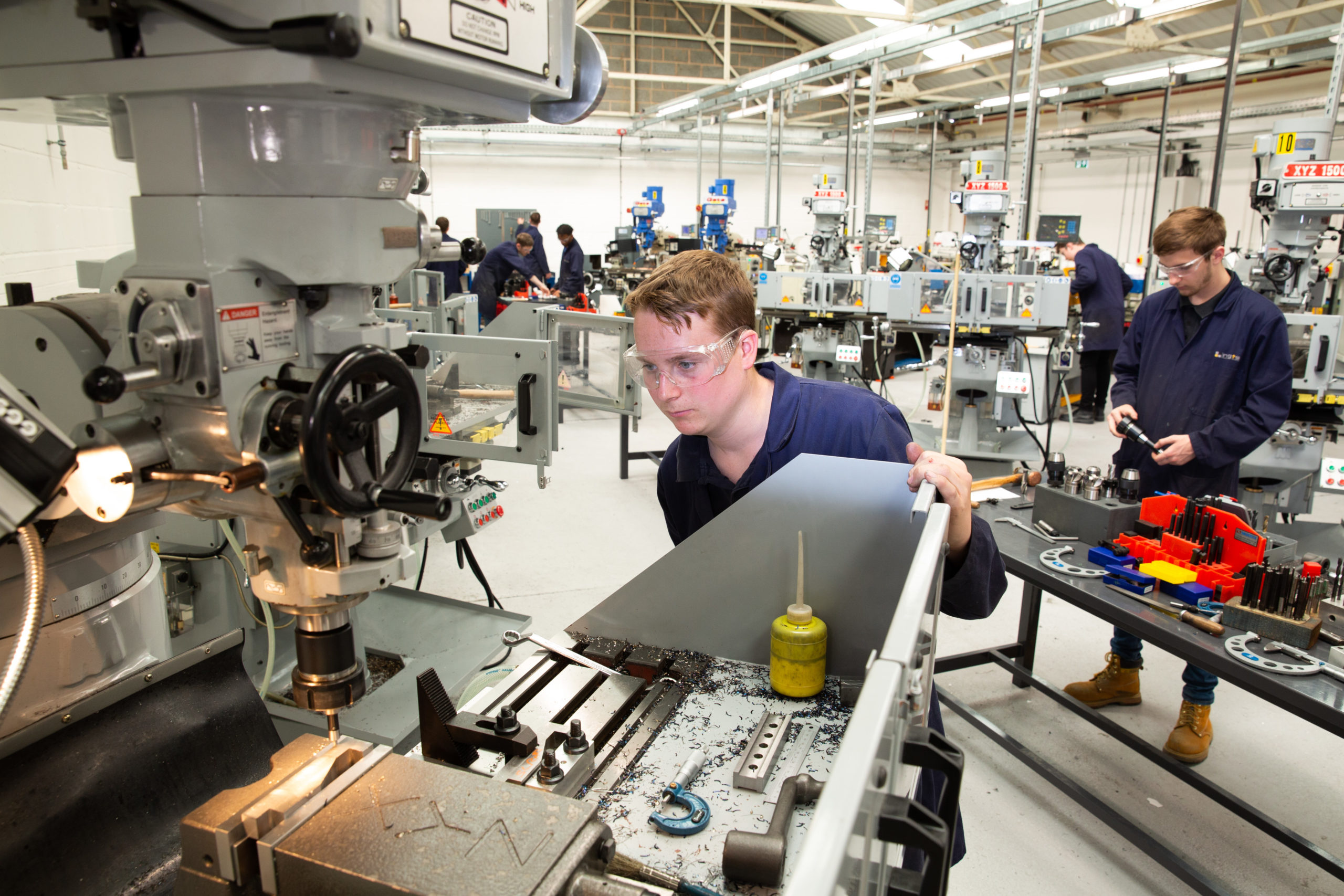 Engineering apprentice using milling machine