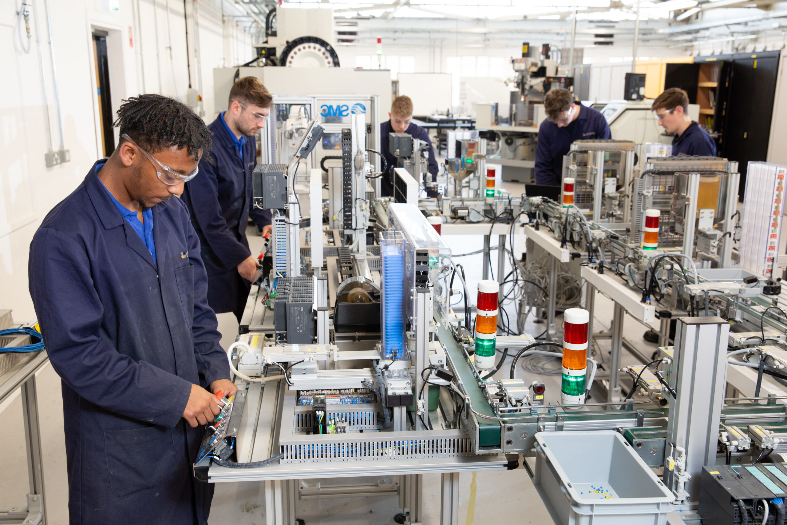 Apprentices using machinery in work room