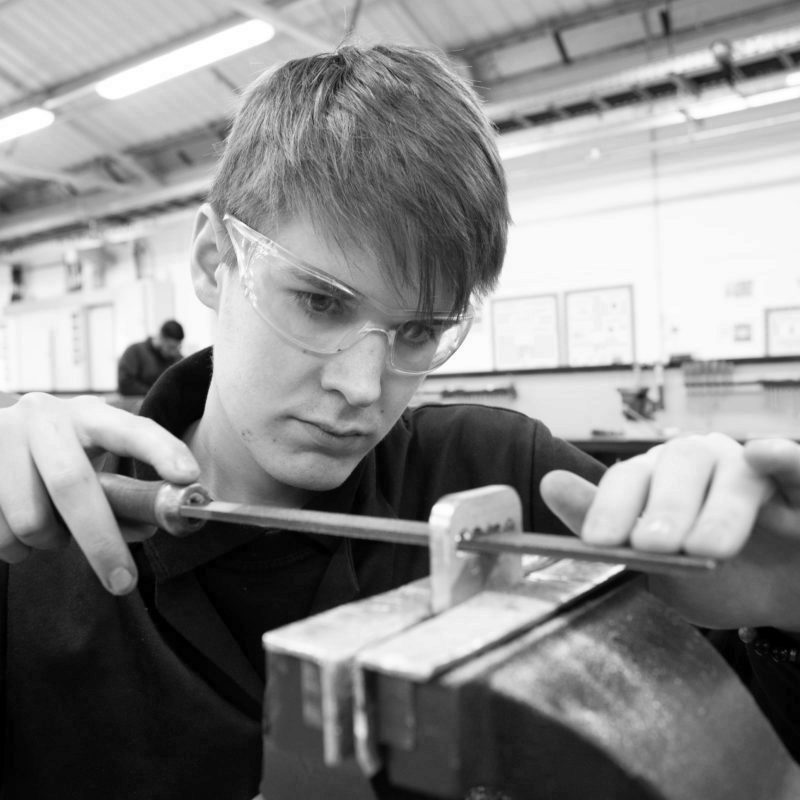 Machinist apprentice hand filing part