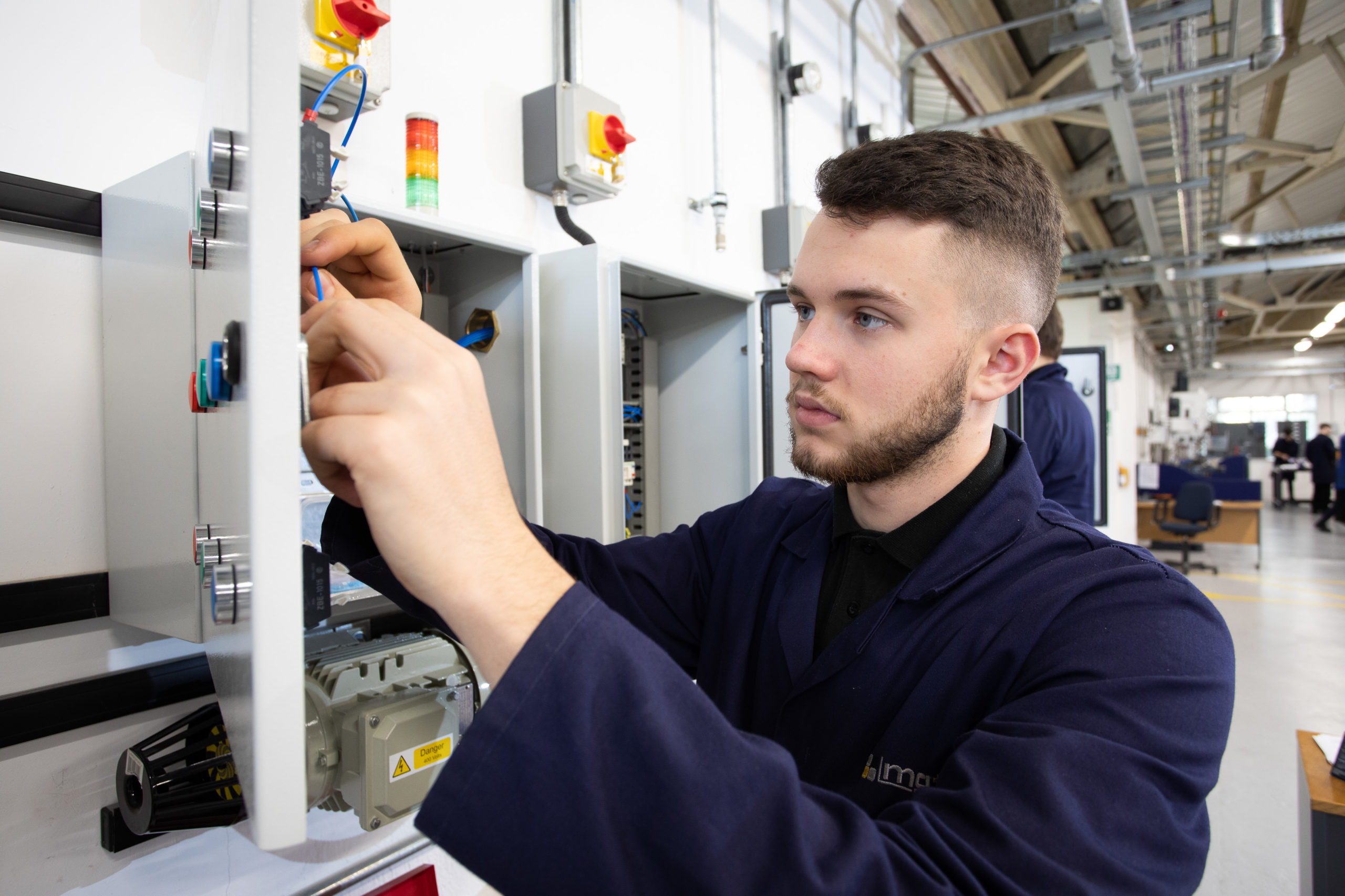 Engineering apprentice working on electrical installation