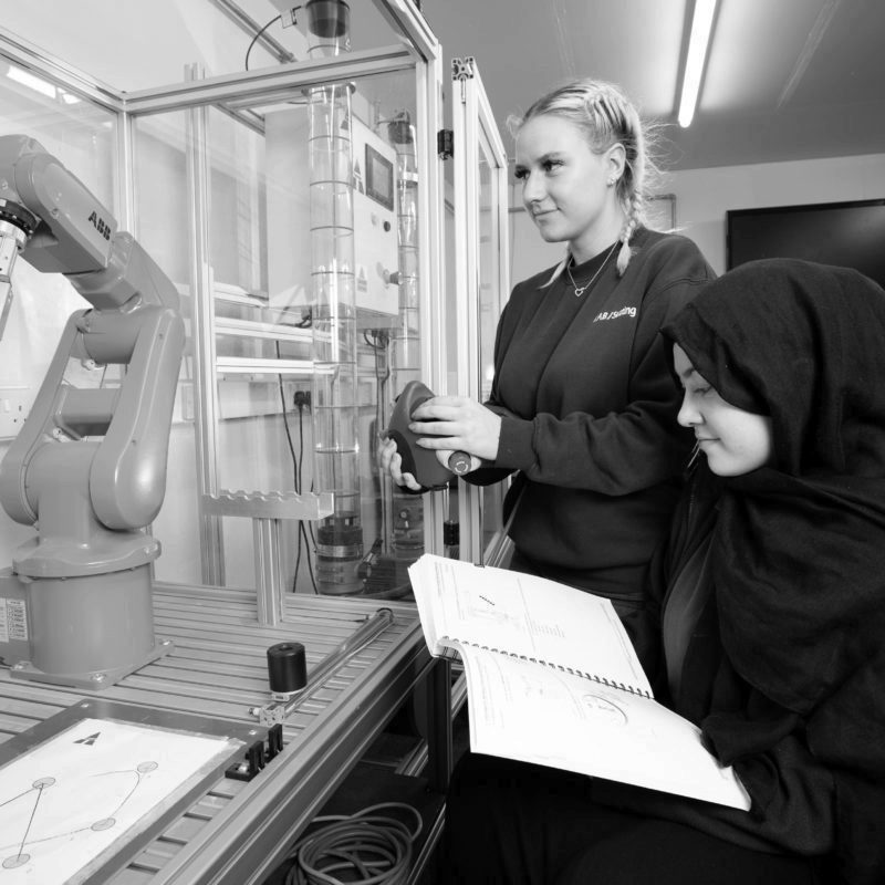 Two apprentices learning robotics programming